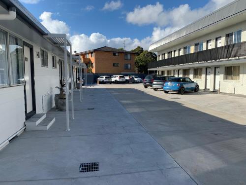 a parking lot with cars parked next to a building at Surf Beach Motel Port in Port Macquarie