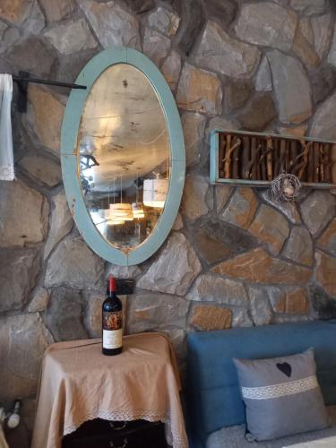 una bottiglia di vino su un tavolo con uno specchio di Apartments 1A JollyKop a Kopaonik