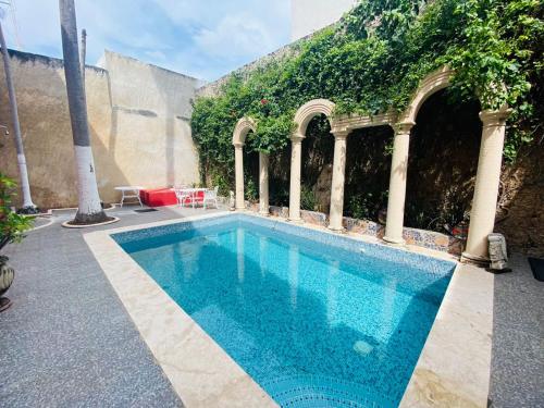 a swimming pool in a courtyard with a building at Catrina & Diego in Mérida