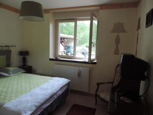 a bedroom with a bed and a window and a chair at Villa Roland en Bourgogne in Chagny