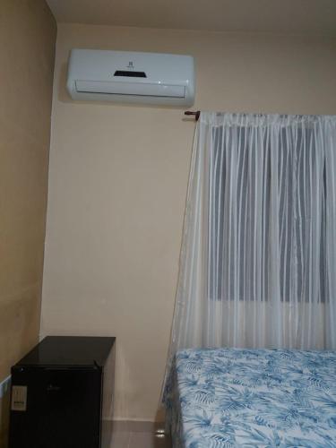 a bedroom with a bed and a air conditioner at Suites Pouso Familiar José e Maria in Paraty