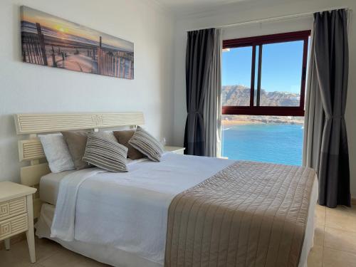 a bedroom with a large bed and a large window at Su Eminencia - Luxury Apartment in Playa del Cura