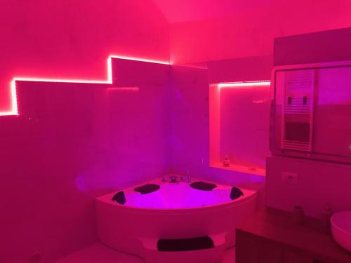 een roze badkamer met een bad en een wastafel bij La Stella d'oro in Orvieto