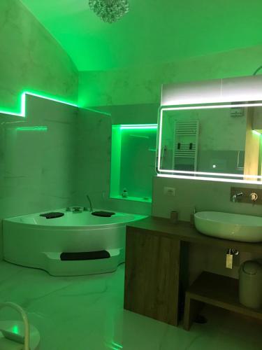 a bathroom with a sink and a tub and green lights at La Stella d'oro in Orvieto