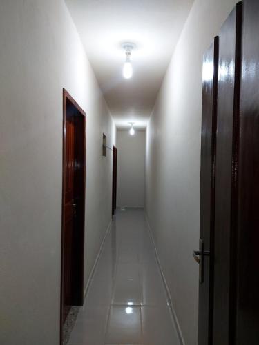 an empty hallway with a door and a corridorngthngthngthngthngthngthngth at Suites Pouso Familiar José e Maria in Paraty