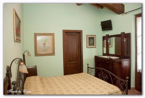 a bedroom with a bed and a dresser and a mirror at Ortoturismo Fonte La Costa in Marciano