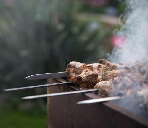 a bunch of meat on a grill with tongs at Mintaro Hideaway in Mintaro