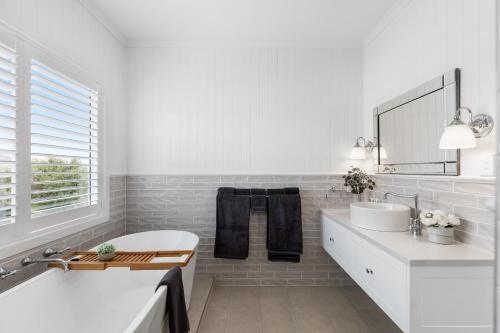 a white bathroom with a tub and a sink at Foxmount Estate - MAGNUS in Mount Gambier