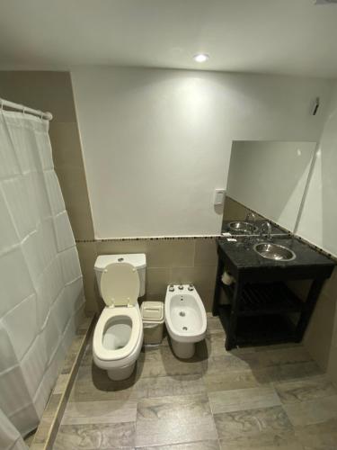 ein Badezimmer mit Toilette und Waschbecken in der Unterkunft La Herradura Village in Merlo