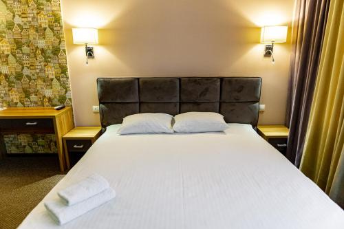 a bedroom with a bed with two towels on it at Hotel Shengen "Шенген" in Kropyvnytskyi