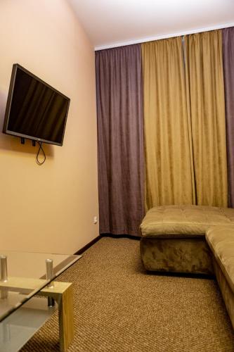 a living room with a couch and a flat screen tv at Hotel Shengen "Шенген" in Kropyvnytskyi