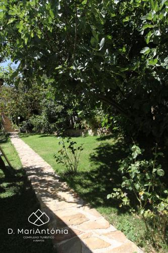 a garden with a tree and a brick path at D. MariAntónia Complexo Turístico in Bragança
