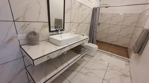 a white bathroom with a sink and a toilet at Las Caletas Lodge in Drake