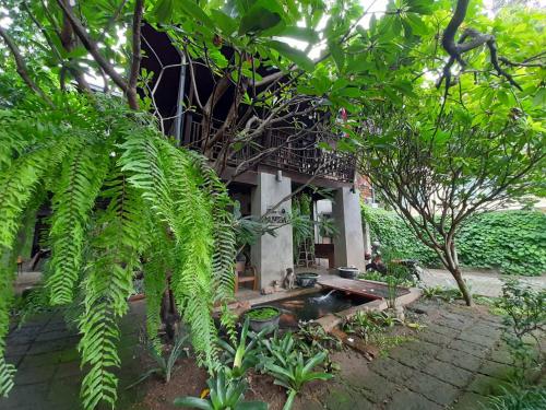 チェンマイにあるバーン ハニバーの木々のある庭園の真ん中にある建物