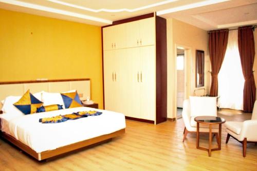 a bedroom with a large bed and a table and chairs at Unic Suites & Hotel in Mbieri