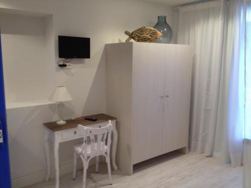 Habitación con escritorio pequeño y armario blanco. en Can Segura Hotel, en Sant Feliu de Guíxols
