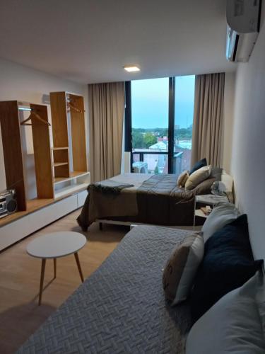 a hotel room with two beds and a large window at Estudio Loft in Mar del Plata