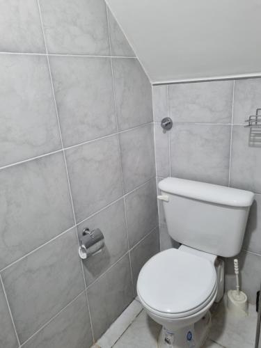 a bathroom with a white toilet and a shower at Departamento en el centro de la ciudad in Mercedes