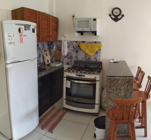 a kitchen with a white refrigerator and a stove at Reserva dos Corais in Cabo de Santo Agostinho