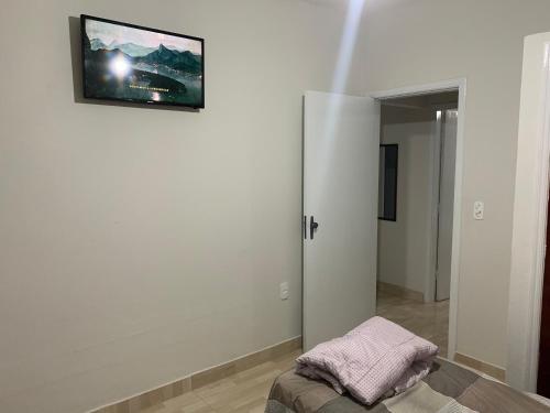 a room with a white wall with a picture on the wall at Ananda pousada chalé in São Pedro
