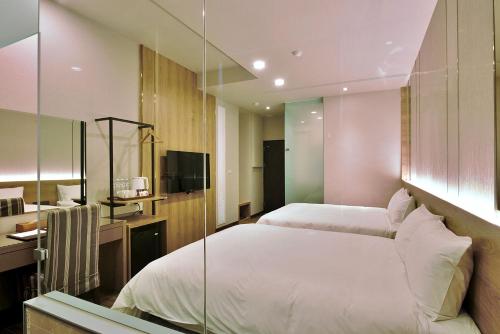 a bedroom with two beds and a glass wall at Muen Yuan Dong Hot Spring Hotel in Jiaoxi
