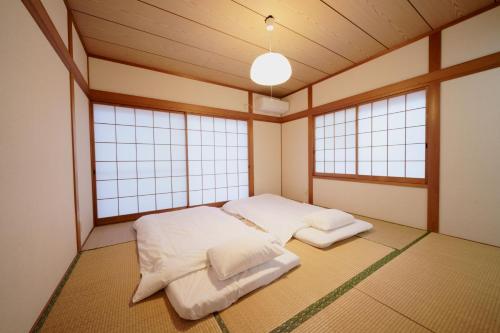 福岡的住宿－Atagohama seaside House，带窗户的客房内设有两张床的房间