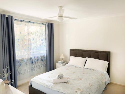 a bedroom with a bed and a large window at Bright & Beautiful Home On The Hills! in Kelmscott