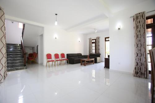 a living room with a black couch and red chairs at NegomboVilla in Negombo