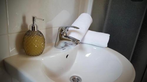 ein Waschbecken mit einem Seifenspender darüber in der Unterkunft Rooms Florida in Tribanj-Krušćica