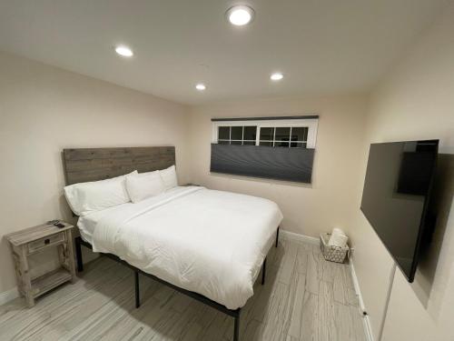 a bedroom with a white bed and a window at Cheerful, Beautifully Remodeled, Modern, Comfortable Home in Los Angeles