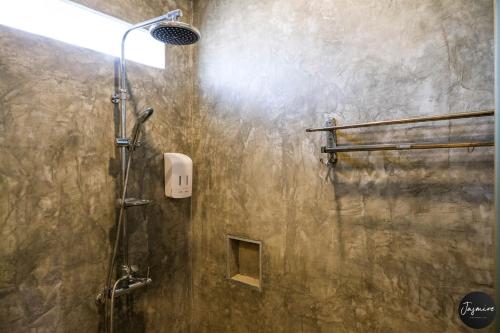 a bathroom with a shower with a shower head at Jasmine Luangprabang Hotel in Luang Prabang
