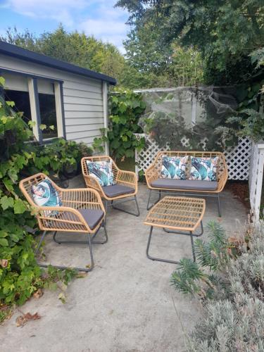a patio with three wicker chairs and a table at Windhaven Bed & Breakfast in Duntroon