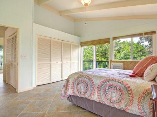 1 dormitorio con 1 cama y ventanas. en Hawaiian Paradise, en Keaau