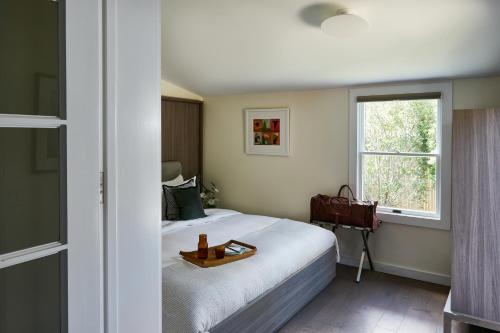 Un dormitorio con una cama con una bandeja de madera. en The Roundtree, Amagansett en Amagansett