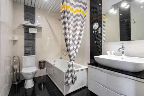 uma casa de banho com um lavatório, uma banheira e um WC. em Hotel 7 Dorog em Irkutsk