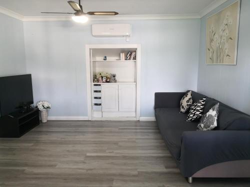 a living room with a couch and a book shelf at So close to Birubi Beach in Anna Bay