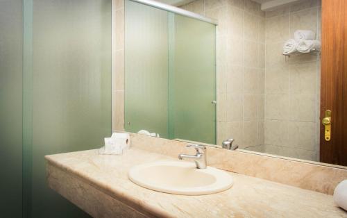 a bathroom with a sink and a mirror at Fast10 Embaixador Hotel - Araújo Viana, Santa Casa, Palácio do Governo in Porto Alegre