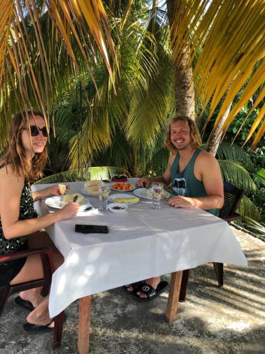 a man and woman sitting at a table with food at Summer Time Hiriketiya in Dickwella