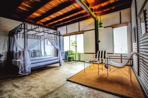 1 dormitorio con cama con dosel, mesa y sillas en Tea and Experience Factory - Thema Collection, en Mandaran Newara