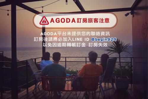 un grupo de personas sentadas en una mesa mirando al océano en 濱境行旅 Begin Inn, en Xiaoliuqiu