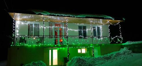 a house with christmas lights on the front of it at Hotel Garbani in Stepantsminda