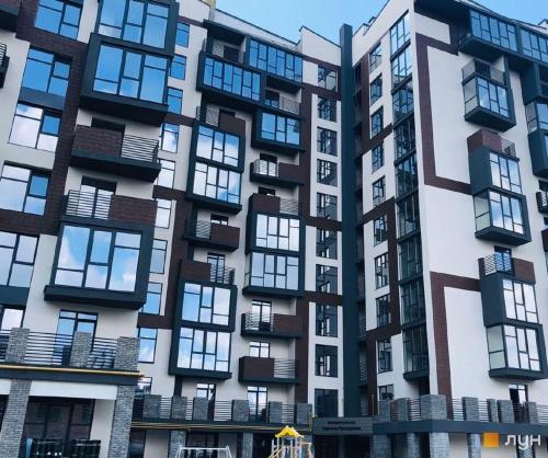 フメリヌィーツィクィイにあるАпартаменти-студія, дизайнерський ремонт, ЦЕНТР, біля ТРК "Либідь Плаза"の多くの窓がある高層アパートメントです。