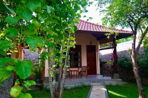 a house with a porch with a table and chairs at 1000 Dream Bungalow in Lovina