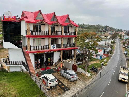 un edificio con techo rojo junto a una calle en HOTEL DEV CHHAYA, en Rānīkhet