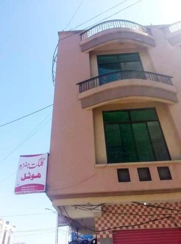 a pink building with a balcony on top of it at Gilgit Hunza Hotel in Mingora