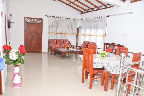 a dining room with a table and some chairs at Rashmi HomeStay in Balapitiya