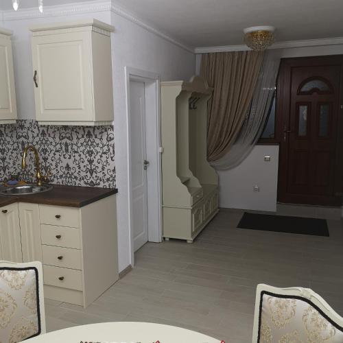 a kitchen with white cabinets and a sink at Ikonomov House in Bansko