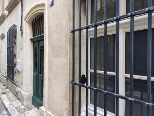 a building with a green door and windows at Au Spa de LLEA in Avignon