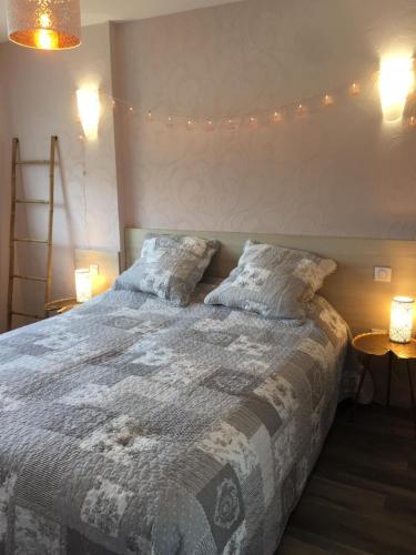 - une chambre dotée d'un lit avec des lumières sur le mur dans l'établissement La Cite des Pins - Piscine chauffee, à Les Sables-dʼOlonne