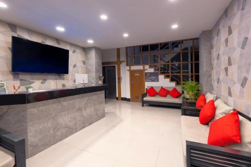 a living room with red pillows and a flat screen tv at Hotel Baya Phuket - Rooftop Pool, Next to Food Market & Steps to Beach in Patong Beach